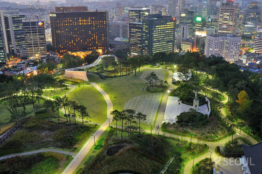Toàn cảnh công viên Namsan khi đêm xuống, phía xa là một đoạn tường thành được tái tạo lại, sau nữa là khách sạn Hilton. Ẩnh: Seoul.go.kr