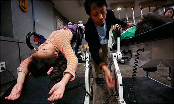 Một HLV thể hình đang hướng dẫn trẻ em Hàn Quốc phương pháp tăng chiều cao.