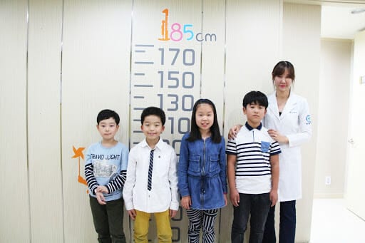 Trẻ em Hàn Quốc trong bệnh viện và thước đo chiều cao ở phía sau.