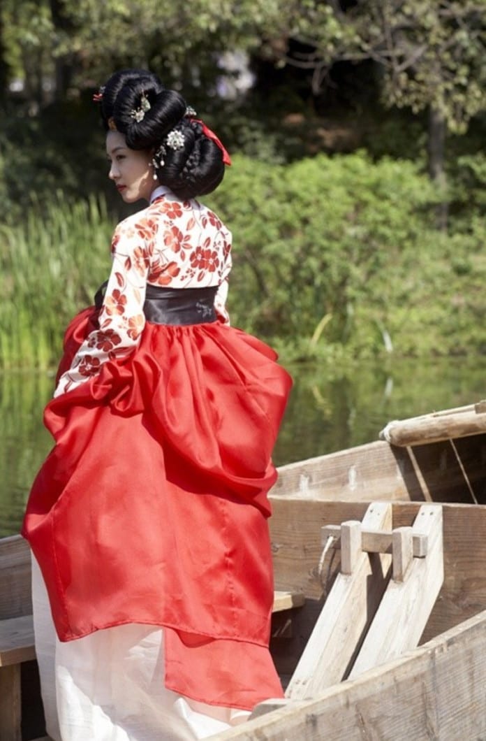 Gisaeng Hanbok - Cô gái mặc bộ hanbok kỹ nữ có phần váy màu đỏ và phần thân trang điểm bằng những bông hoa trên nền trắng.