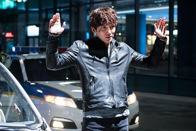 Ji Chang Wook trong một phân cảnh của phim hành động Healer với quần jeans và áo da màu đen.