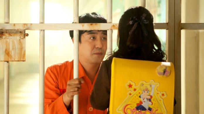 Một cảnh trong phim Điều Kỳ diệu ở Phòng giam số 7: Hai bố con Gong Yoo gặp nhau qua song sắt nhà tù.