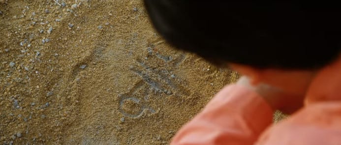 Một cảnh trong phim Điều Kỳ diệu ở Phòng giam số 7: Yong Goo viết tên con trên cát.