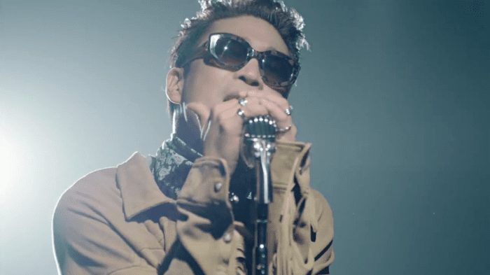 MC Mong đeo kính mát, cầm mic hát trên sân khấu.