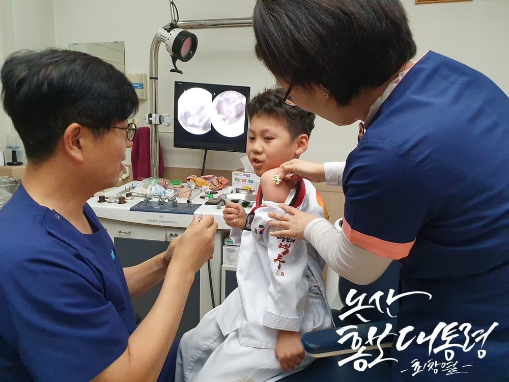 Ảnh minh họa các bác sĩ đang tiêm chủng dự phòng cho bé trai ở Hàn Quốc.
